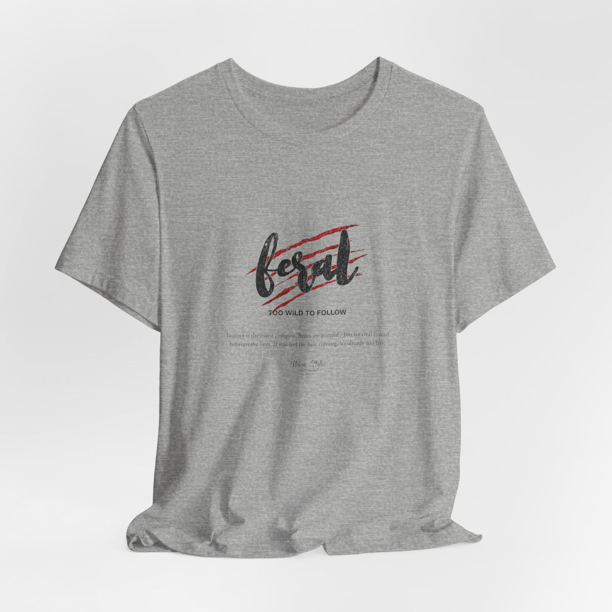 The FERAL t-shirt in Athletic Heather — untamed thoughts in neutral tones.