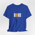 The ROOKIE t-shirt in True Royal — carrying big dreams in unsteady hands.