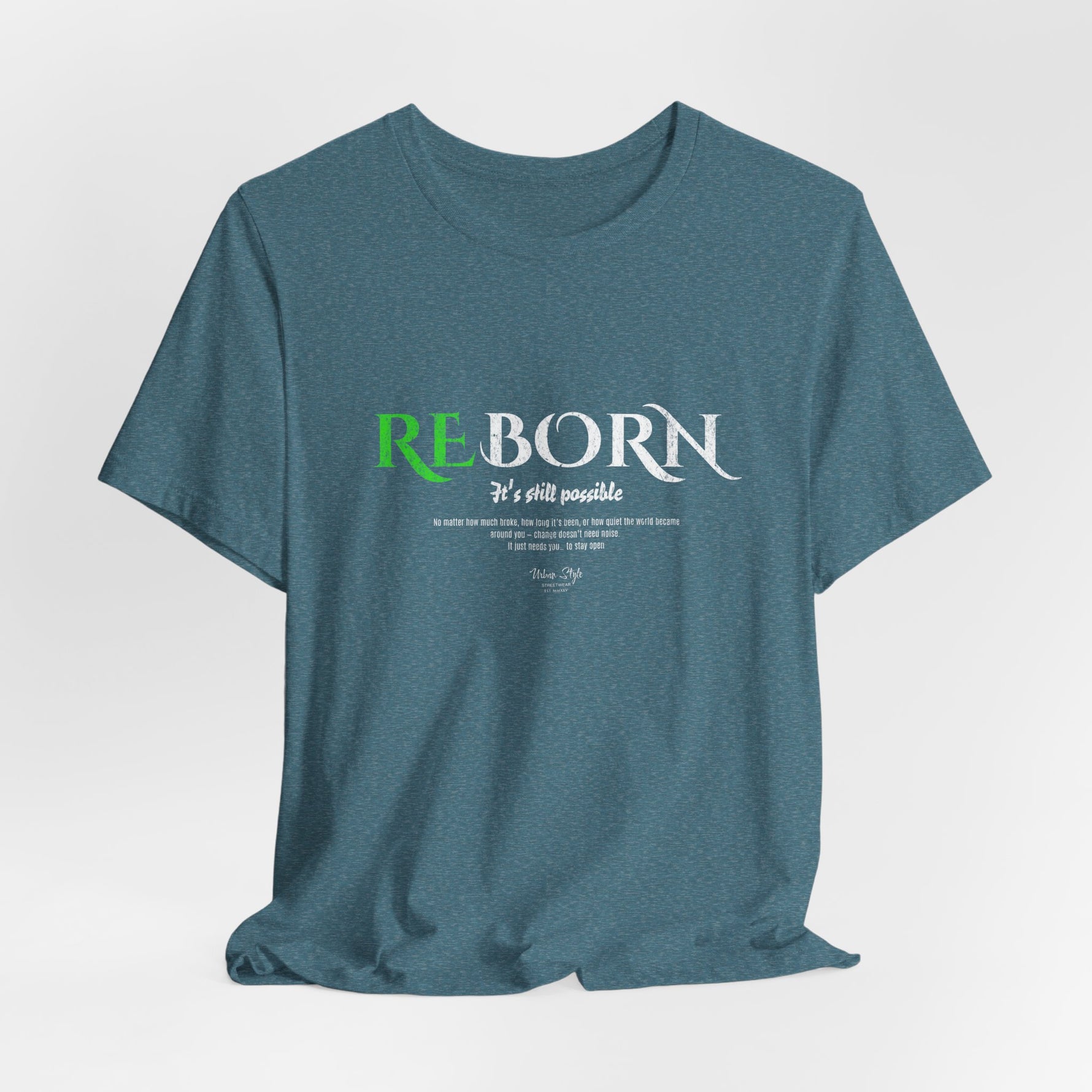 The REBORN t-shirt in Heather Deep Teal — rebirth in still waters, where silence reshapes strength.