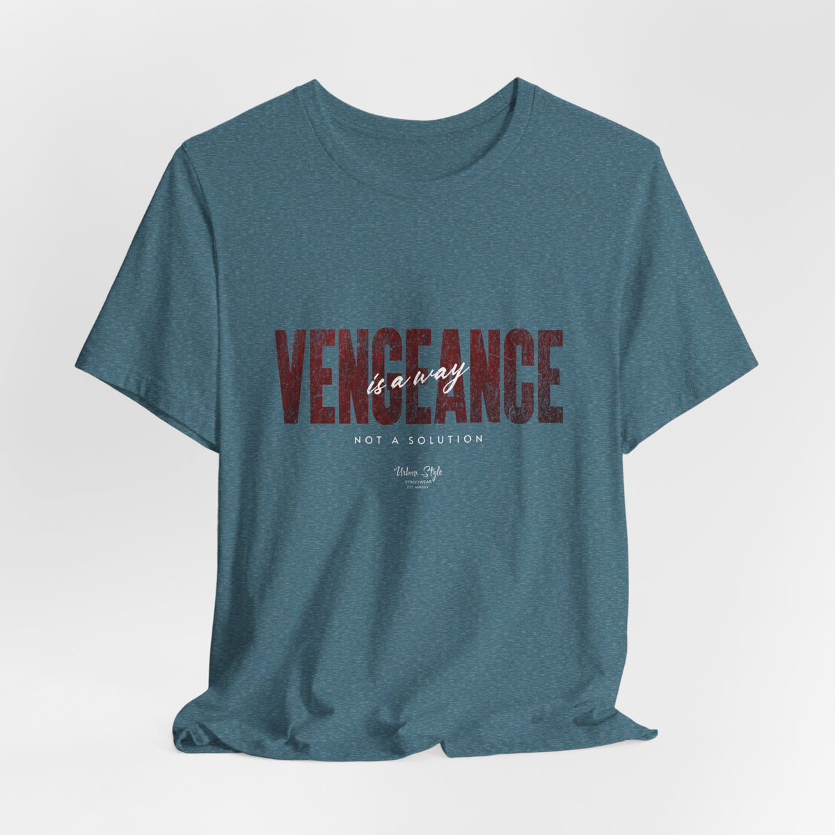 The VENGEANCE t-shirt in Heather Deep Teal — eerie and thoughtful, like a calm before impact.