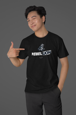REBELLION black tee by KRASSWERK – worn by male model in clean studio setup, playful confident pose pointing at lion graphic