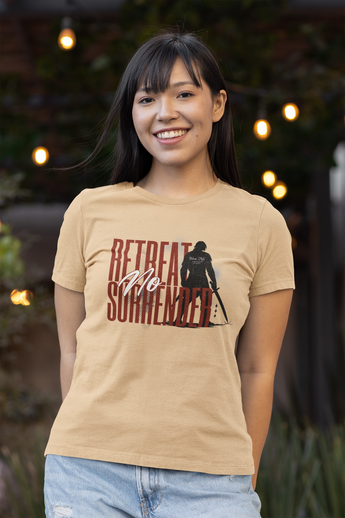 “No Retreat No Surrender” sanddune tee by KRASSWERK – worn by smiling female model in outdoor setting with warm ambient lights and casual summer style