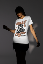 “Where Is My Coffee?” white tee by KRASSWERK – worn by female model in moody lighting, zombie artwork contrasted against soft shadows
