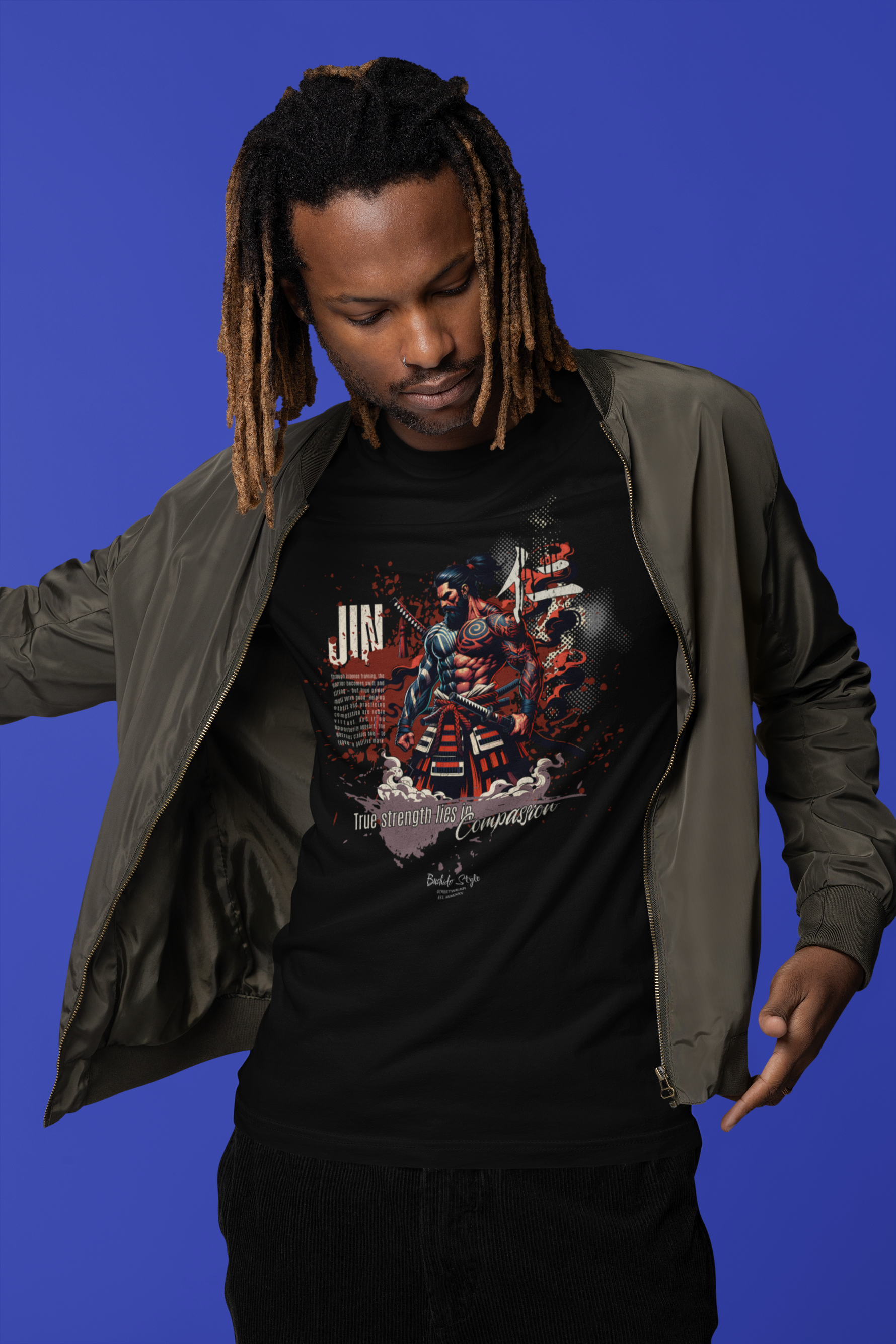 “JIN” black tee by KRASSWERK – worn by male model in streetwear jacket with blue backdrop, samurai-inspired warrior graphic symbolizing strength and compassion