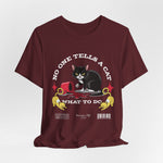 The No One Tells a Cat t-shirt in maroon — ghost mockup showing a deep wine red fabric tone with no background or model.