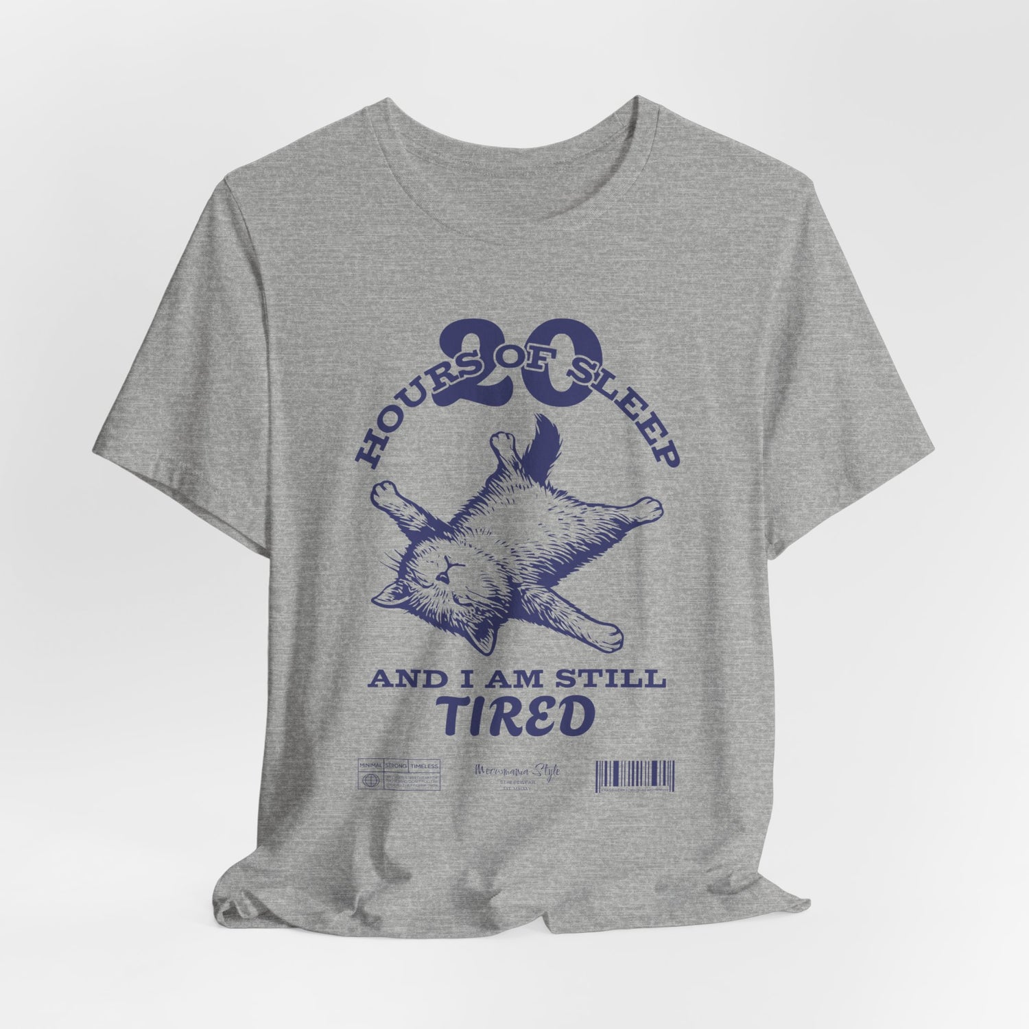 3D mockup of the “STILL TIRED” t-shirt in Athletic Heather — light grey with speckled texture, no background or model.