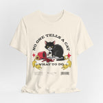 The No One Tells a Cat t-shirt in natural — ghost mockup showing an off-white, creamy fabric tone with no background or model.