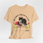 The No One Tells a Cat t-shirt in sanddune — ghost mockup showing a pale beige tone with no background or model.