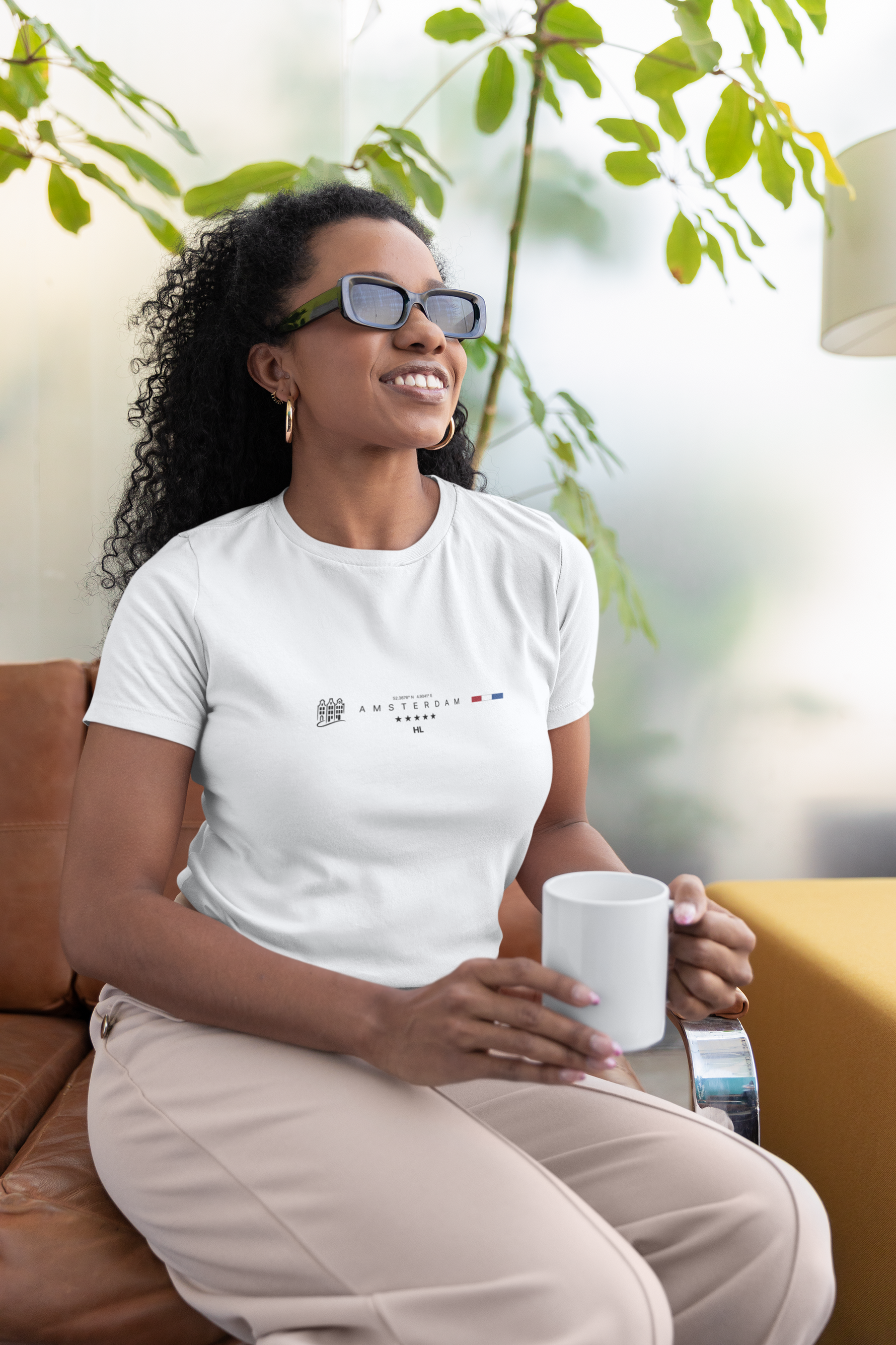Woman sitting on a couch holding a mug with a blurred outdoor background
