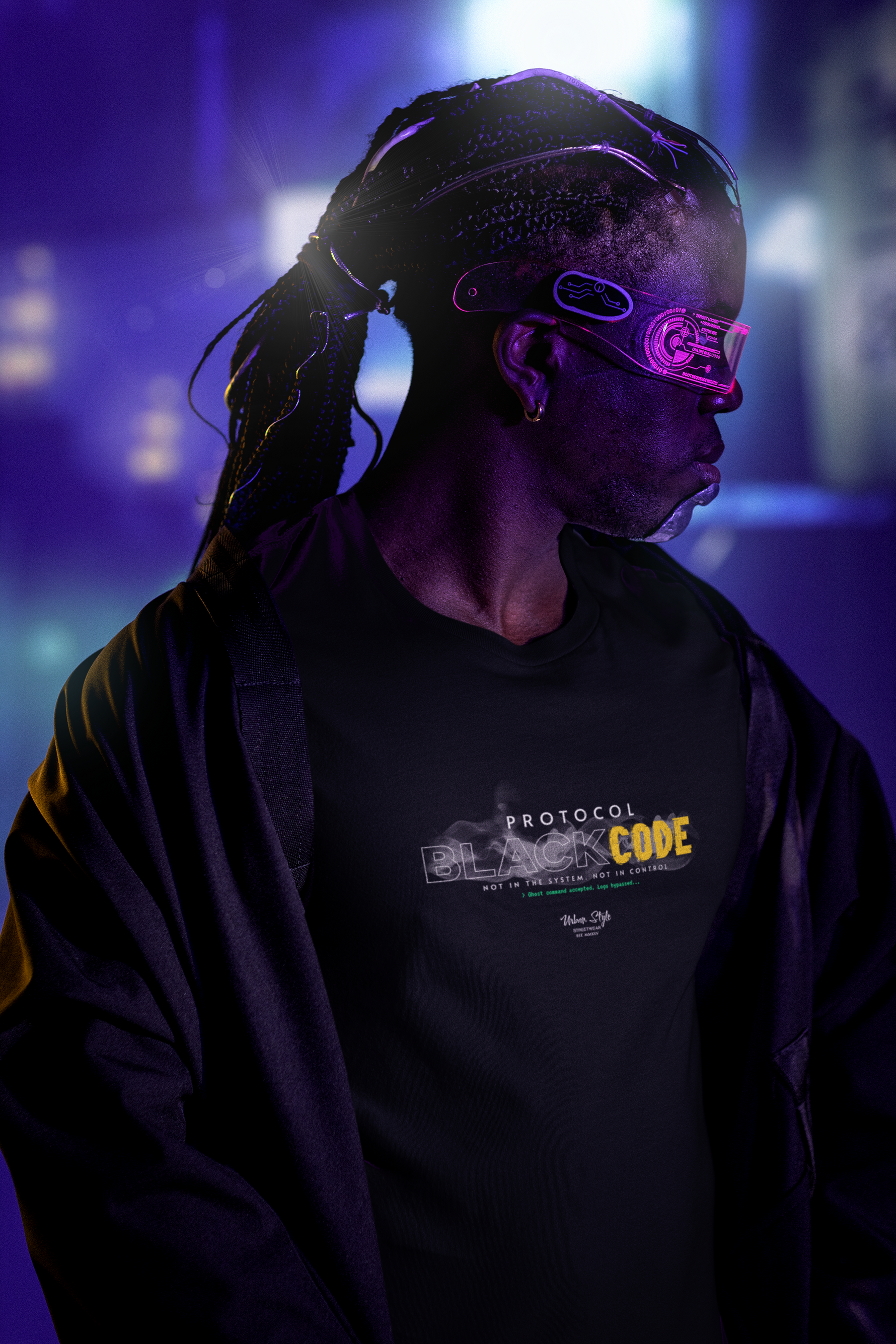 A futuristic lifestyle shot of a man wearing the “PROTOCOL BLACKCODE” black t-shirt. The scene is bathed in deep violet and electric blue lighting, with the model in neon pink visor glasses and tech-braided hair. The shirt’s design features smokey effects around the word “BLACK,” with “CODE” highlighted in glitchy yellow, paired with the text “NOT IN THE SYSTEM. NOT IN CONTROL.” — creating a strong cyberpunk aesthetic.
