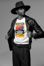 A confident male model in a wide-brim black hat and leather jacket opens his coat to reveal a bold white t-shirt featuring a vibrant, 3D-style brain graphic under the headline “WARNING: BRAIN ACTIVITY DETECTED.” The yellow-red color palette and barcode label give the design a punchy, high-alert aesthetic.