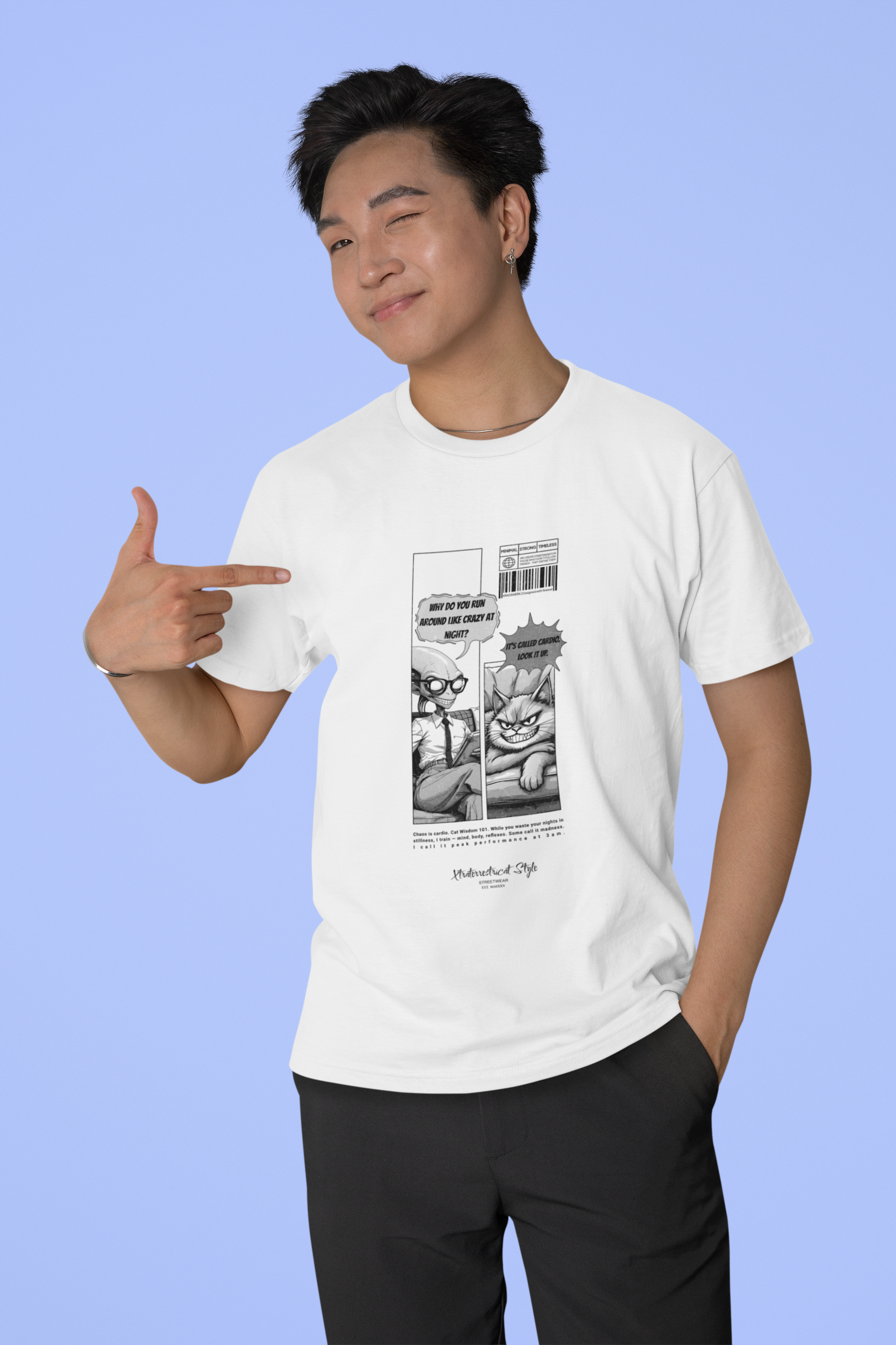 A man in a white t-shirt points confidently at his chest while winking. The shirt features a black-and-white comic print showing an alien therapist and a smug cat. The alien asks, “Why do you run around like crazy at night?” and the cat responds, “It’s called cardio. Look it up.” The background is a smooth pastel blue, adding a light, playful tone to the scene.
