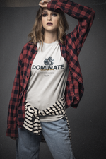 Confident woman wearing the DOMINATE t-shirt with layered streetwear — bold makeup, flannel shirt, and attitude. The mechanical fist on the tee contrasts with her casual yet commanding stance. A quiet kind of power that doesn’t ask.
