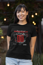 A smiling young woman stands outdoors in front of warm hanging lights, wearing a black Krasswerk t-shirt. The design features bold red and white text that reads “Keep your life simple – DREAM IT AND DO”, accompanied by mirrored butterflies, paint splashes, and barcode-style graphics, creating a dynamic urban vibe.