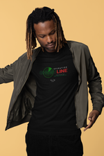 A man with dreadlocks looks down while adjusting his olive bomber jacket, revealing a black “OPERATION GHOSTLINE” t-shirt. The shirt design features a green radar motif and red glitch-style text. Set against a soft beige background, the scene blends urban edge with tactical flair.