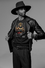 Black and white photo of a confident man revealing his black t-shirt by pulling open his leather jacket. He wears a wide-brimmed hat, multiple bracelets, and dark pleated pants. The t-shirt displays the “LEO” zodiac design — a tattooed lion in a mugshot pose, wearing a crown, flexing a muscular arm, and holding a nameplate. “CRIME: Extreme Ego” is written underneath, stamped with “GUILTY.” Grey studio backdrop. The scene emphasizes bold attitude and dominance.