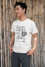 Male model outdoors in front of a bamboo wall, wearing the white “Too Many Voices In My Head” tee. The bold black text and creepy smiley detail pop against the clean background. A subtle rebel vibe.