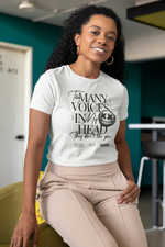 Female model seated in a modern indoor space, smiling confidently in the white “Too Many Voices In My Head” tee. Edgy black typography with a scratched face detail stands out on the soft fabric. Stylish and expressive look.