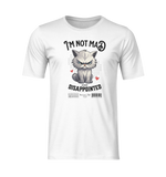 Front-facing white t-shirt with no model or background, shown in a clean 3D mockup style. The shirt features an angry fluffy grey cat with a scowl, surrounded by red hearts and halftone dots. Bold white text above reads “I’m Not Mad,” with “Just Disappointed” below the character. The design is centered and crisp, highlighting the humorous contrast between love and fury.