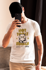 A man in a black cap taking a selfie with his phone, wearing a white t-shirt that features a grumpy Persian cat illustration and bold yellow text reading ‘NOT TODAY HUMAN’. He stands in soft natural light, with warm tones and shadows in the background, reinforcing the mood of relaxed resistance the shirt conveys.
