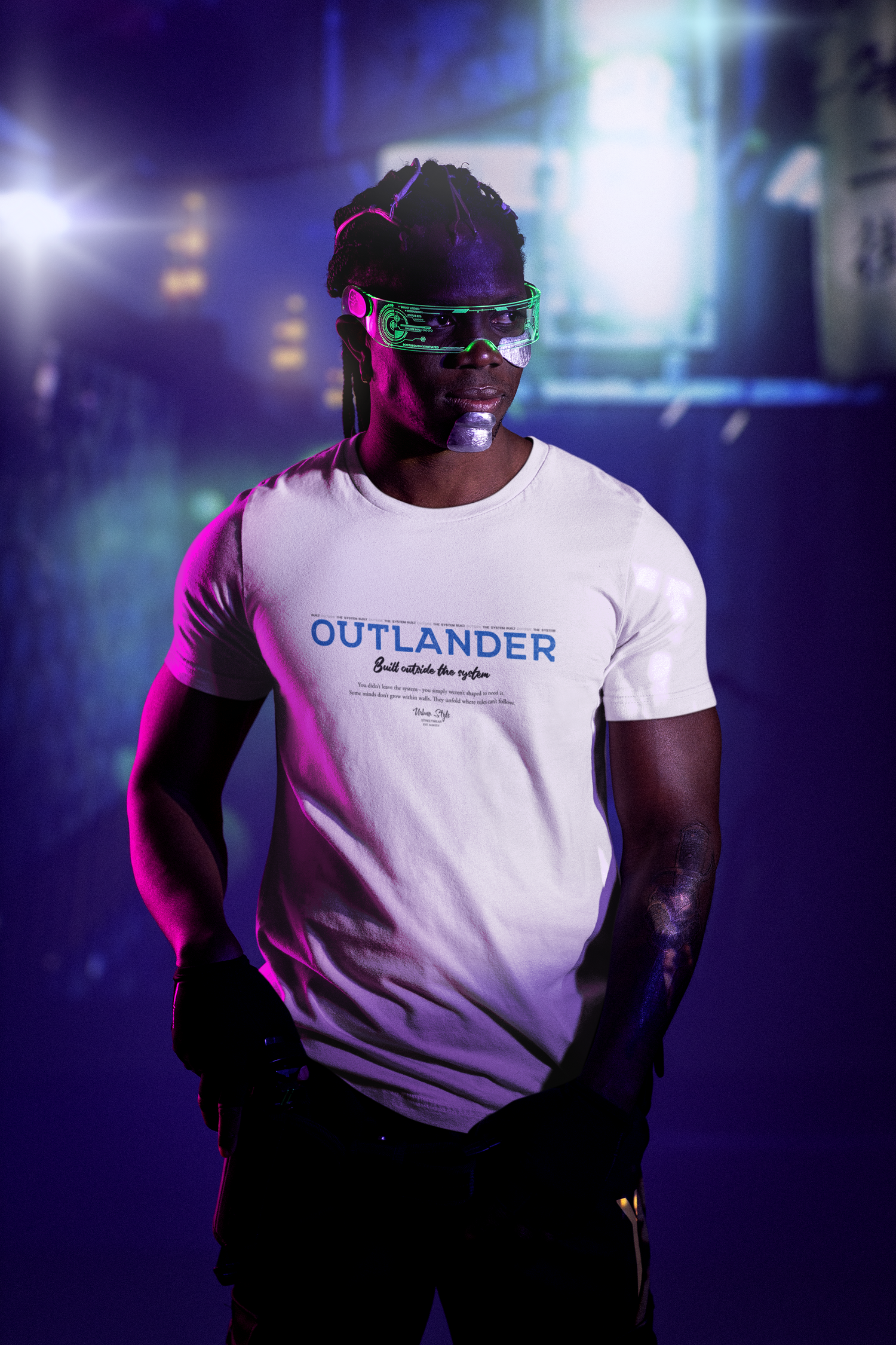 Model stands in a cyberpunk-inspired neon setting wearing the white OUTLANDER t-shirt — bold blue text “Built outside the system” visible under futuristic lighting.