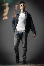 Male model in urban denim style wearing the REBORN t-shirt in white. Hands in pockets, chin raised with confidence, and yellow-tinted glasses—projecting cool resilience. “It’s still possible” slogan and minimalist design are clearly visible on chest.