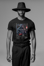 Black t-shirt worn by a man with a wide-brimmed hat, standing confidently in a studio setting. The design features a masked scorpion warrior holding a flame with a mugshot backdrop.