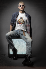 Studio portrait — man sits on an old static TV in the TAURUS T-shirt (white), styled with combat boots and retro sunglasses. Shirt features a mugshot of a muscular bull with tattoos. Caption below: “CRIME: Change Resistance. Refused to move… again.” A style for the immovable rebel.