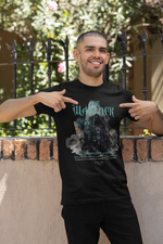 A confident man smiles while pointing at his black THE WARLOCK t-shirt — embracing arcane power under the midday sun.