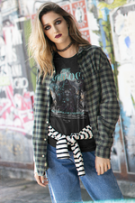 A young woman with smoky eye makeup stands against a graffiti wall, wearing THE WARLOCK t-shirt in black — channelling dark mystique and unspoken power.