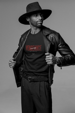 Confident man in a wide-brimmed hat and leather jacket pulls open his coat to reveal a bold KRASSWERK “VENGEANCE — is a way, not a solution” t-shirt. Shot in high-contrast black and white, the image channels a modern gunslinger aesthetic — calm, composed, and unapologetically decisive. His intense gaze and minimal styling reinforce the shirt’s message: vengeance isn’t about drama, it’s about direction.